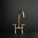 Golden arc unlacquered brass bridge kitchen faucet – elegant curved legs, front view