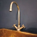 Unlacquered brass gooseneck bathroom faucet – side view showing patina